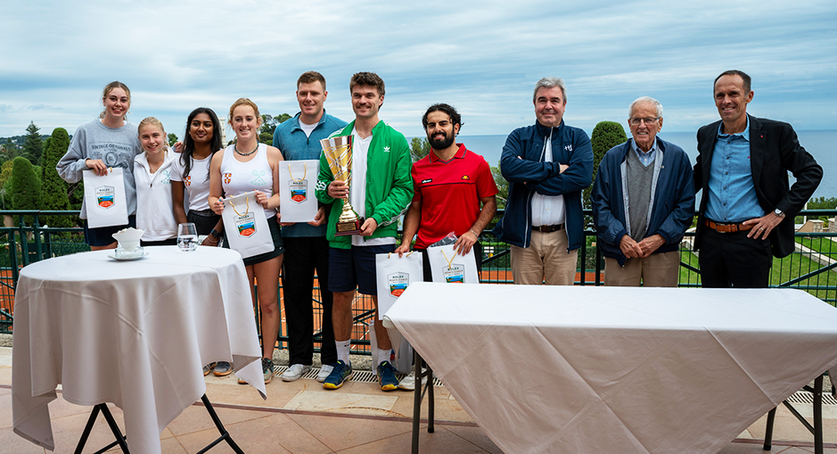 Photo de groupe des participants et organisateurs lors de la remise des prix de l'HEC Clay Court Challenge 2024, avec vue sur la mer en arrière-plan. Les gagnants tiennent un trophée et des sacs cadeaux.