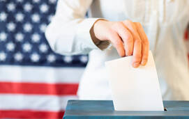 knowledge_a hand voting in front of an US flag