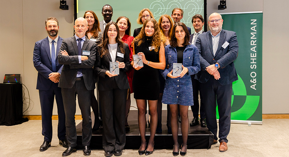 award recipients and organizers during the Allen & Overy Shearman event, with participants holding trophies and posing on stage