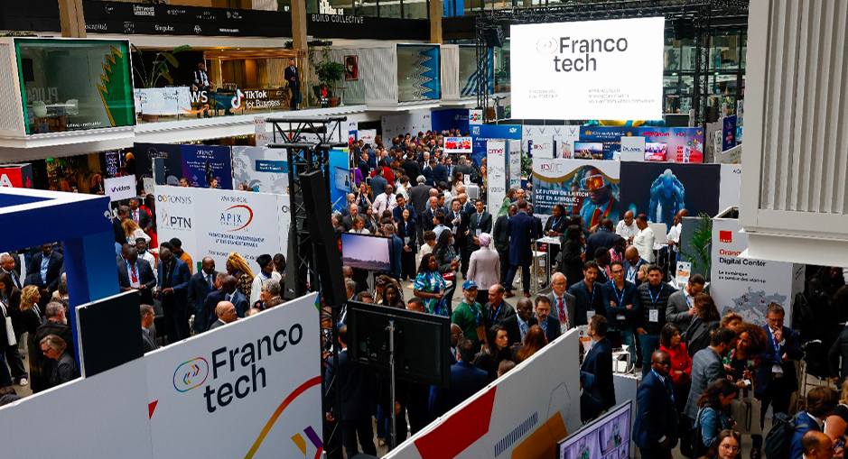 A large crowd attending the FrancoTech event, surrounded by various company booths and technology displays, in a busy exhibition hall