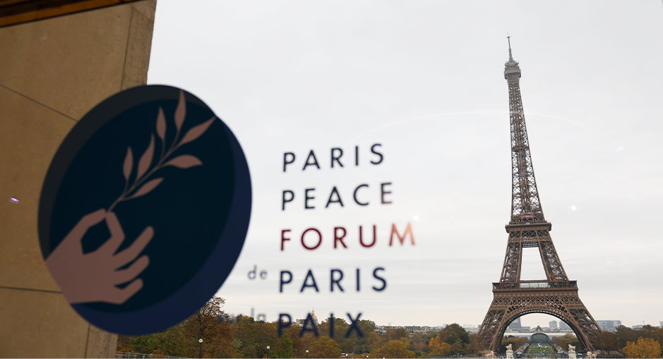 Logo of the Paris Peace Forum with a view of the Eiffel Tower through a window, symbolizing international cooperation and commitment to peace.